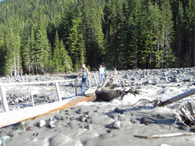 Crossing the White River on a log bridge.